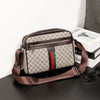 A brown men's letter print crossbody sling bag resting on a dark surface next to a stack of books.