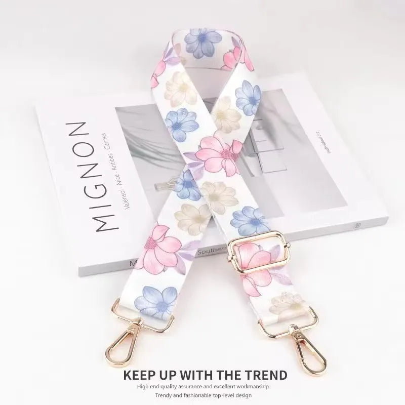 A white and pink floral patterned fabric strap is displayed on a white background.