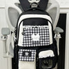 A black and white patterned backpack hanging on a white coat rack.