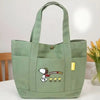 A light green canvas shoulder bag featuring a Snoopy cartoon design.