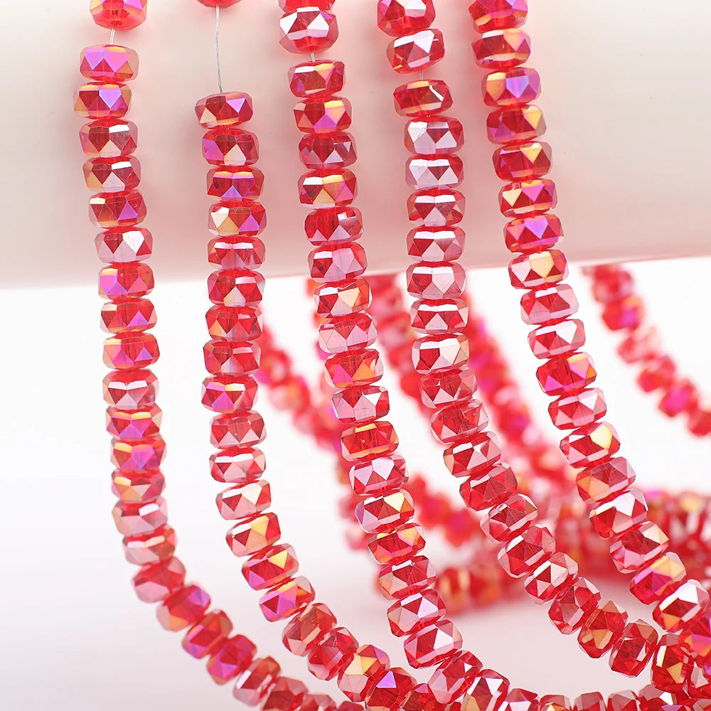 A string of faceted red and pink crystal glass beads in a wheel shape for jewelry making