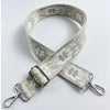 A beige patterned fabric strap with silver hardware, used as a crossbody bag strap.