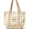 Bolso de lona a rayas beige y blanco con el logo de Trader Joe's en la parte frontal.