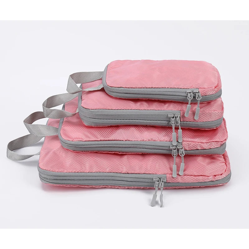 A set of four pink and gray vertical travel organizer bags stacked together.
