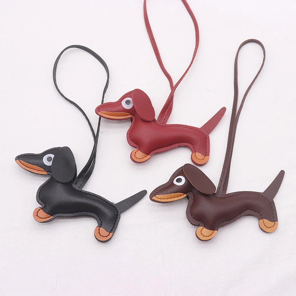 A set of leather dachshund dog charms with attached strings and ear loops.