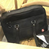 A black women's Japanese style PU shoulder bag with a flap and leather trim is shown on a wooden surface.