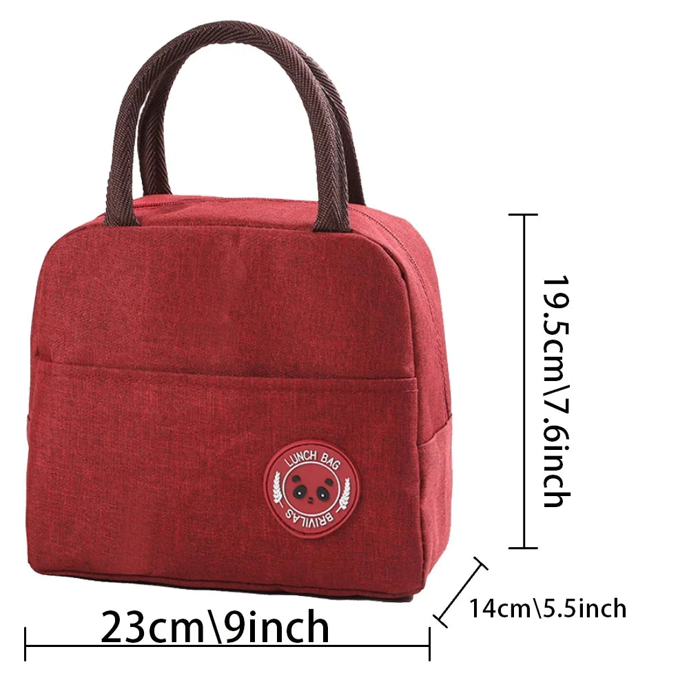 A maroon insulated canvas lunch bag with a brown strap and a circular logo on the front.