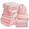 A set of seven pink folding travel organizer bags and storage pouches.