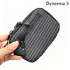 Une pochette utilitaire noire en Dyneema 3 à motif grille diamant tenue par une main.