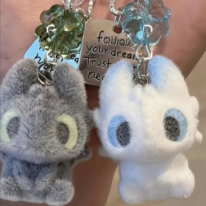A pair of Toothless cartoon keychain pendants featuring a gray and white rabbit design with translucent green and blue charms
