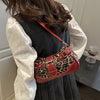 Sac à épaule en PU à imprimé léopard rouge, gros plan, sur fond sombre.