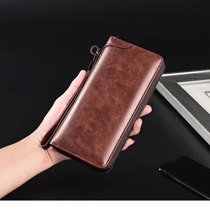 A hand holds a brown PU leather zipper wallet for business on a dark surface.