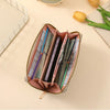 A pink zippered wallet filled with various credit cards and cash, resting on a light surface next to a yellow tulip.