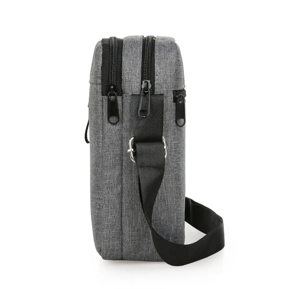 A gray durable waterproof crossbody bag for men with a black strap and zippered compartments.
