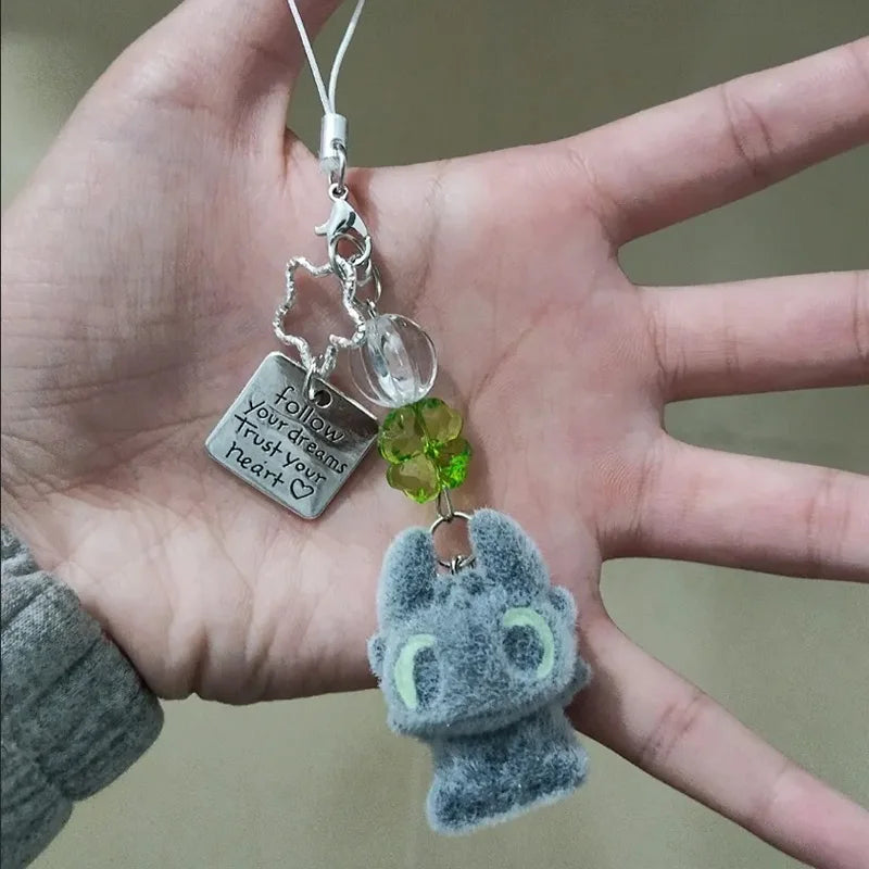 A silver keychain pendant featuring a Toothless cartoon character charm hanging from a silver chain.