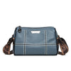 A slate blue luxury cowhide shoulder bag with brown leather trim and stitching.