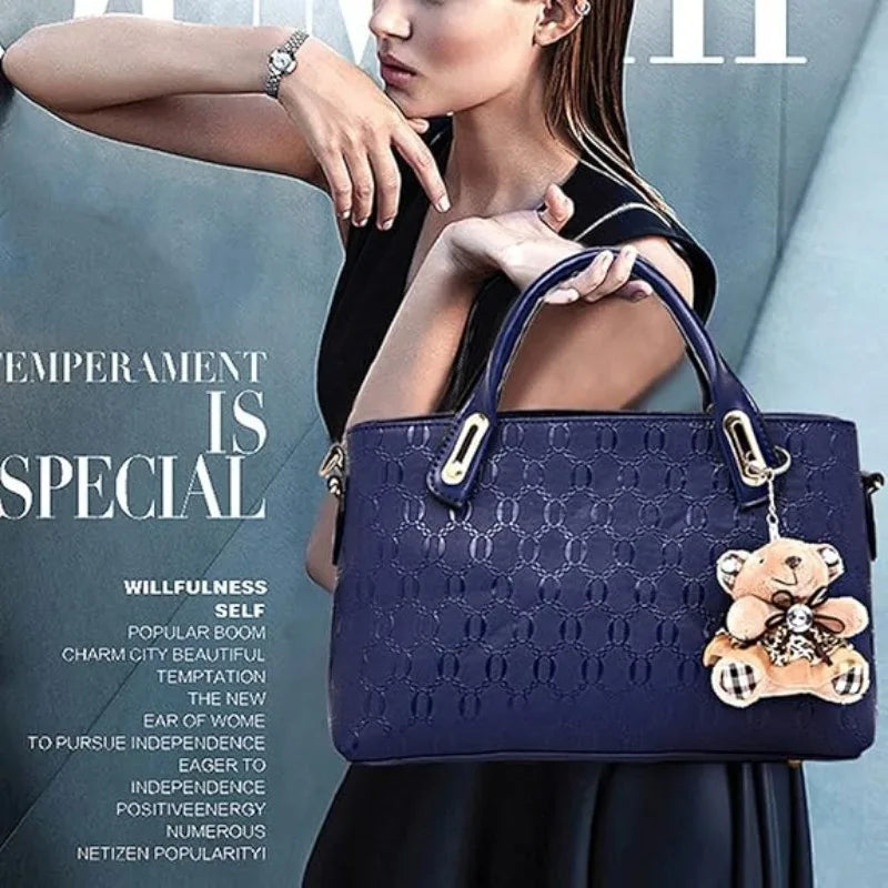 A model holds a dark blue embossed PU handbag against a gray background.