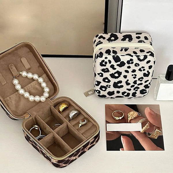 Boîte de rangement en cuir PU à imprimé léopard avec pochette zippée et inserts en velours, à côté d'une trousse assortie à f