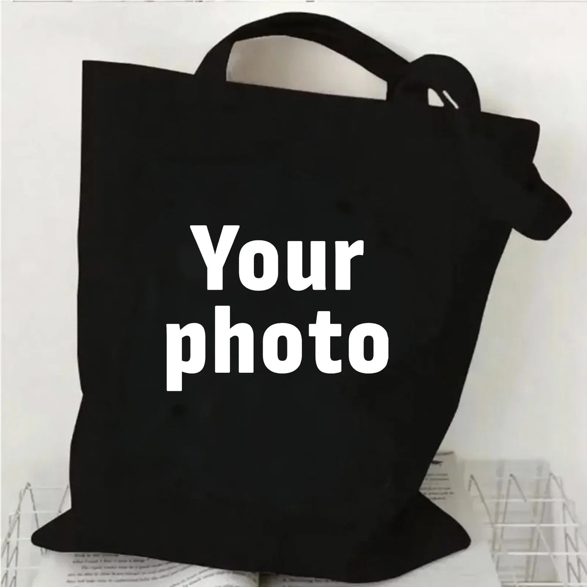 Sac de courses en toile noire avec du texte blanc indiquant Votre photo
