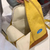A yellow and brown banana-shaped backpack is shown open, displaying the interior lining.
