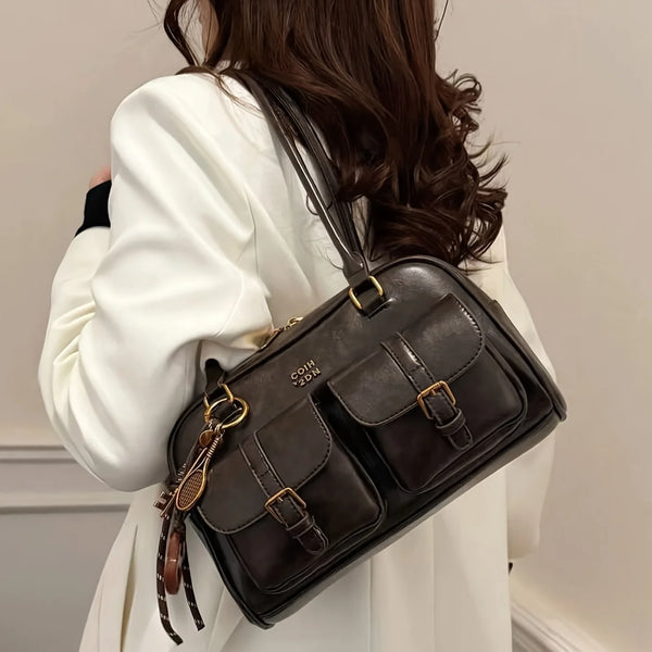 Dunkelbraunes Vintage-Briefdruck-Crossbody-Bag, getragen von einer Person in einem weißen Blazer.