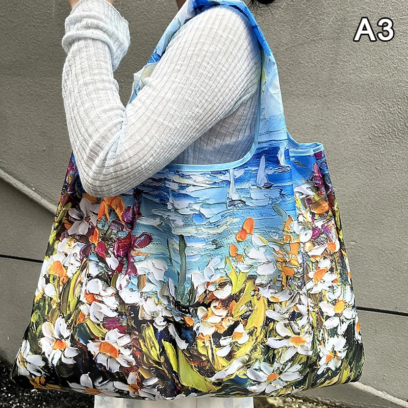 A woman holds a large, colorful floral print nylon shopping tote bag against a gray wall.