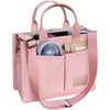 A pink canvas tote handbag with leather accents and a mesh lining, featuring two separate compartments.