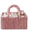 A pink flannel diaper caddy organizer filled with soft white and beige baby items.