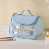 Sac à toilette transparent bleu clair et imperméable avec poignée, exposé sur une surface blanche.