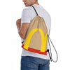 A man wearing a white t-shirt is holding a beige kraft paper drawstring bag with a yellow McDonald's arch design.