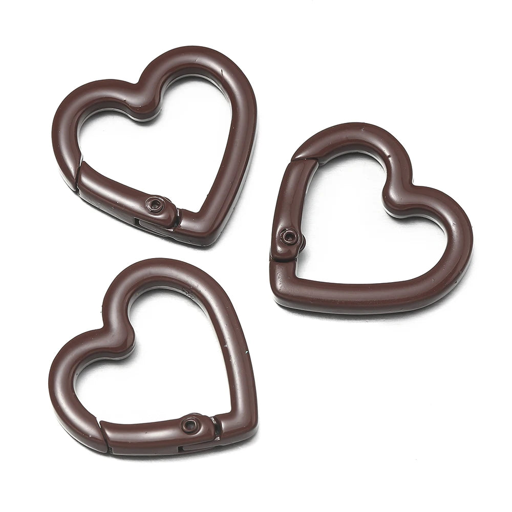 Three heart-shaped metal spring clasps in a dark brown color shown against a white background.