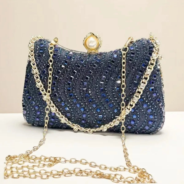 A dark blue rhinestone diamond inlay evening clutch bag with gold chain detailing.