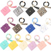 A collection of silicone bead bracelets and leather card holders in various colors and patterns.