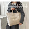 A woman holds a clear waterproof PVC tote bag with gold lettering against a light background.