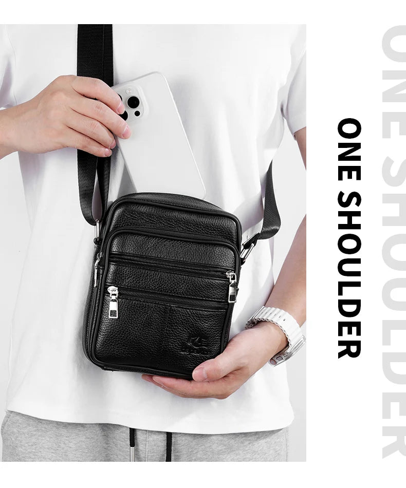 A black vintage leather messenger bag is shown being held by a person against a white shirt.