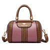 A brown leather shoulder bag with gold hardware and a woven pattern in dusty pink.
