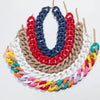 A choker necklace made of colorful matte acrylic chains in shades of red, blue, white, tan, and green.