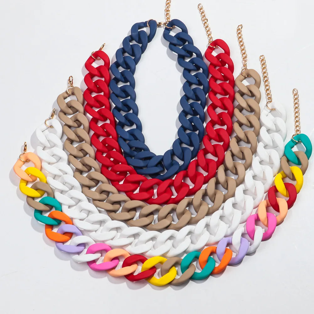 A choker necklace made of colorful matte acrylic chains in shades of red, blue, white, tan, and green.