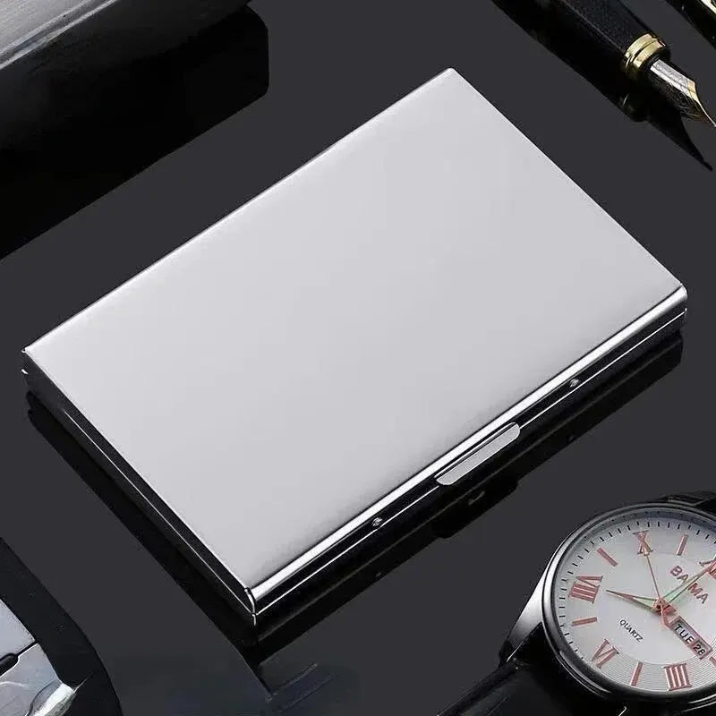 Un porte-cartes métallique fin et blanc à dix emplacements, posé sur une surface sombre à côté d'une montre-bracelet.