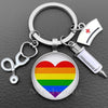 Silver keychain featuring a heart design with the Pride rainbow flag and a medical syringe charm