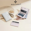 A collection of Baellerry wallets and card holders in pink, white, and beige tones displayed on a light background.