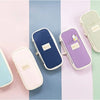 Collection de trousses en toile pastel bleu, violet et rose sur fond clair.