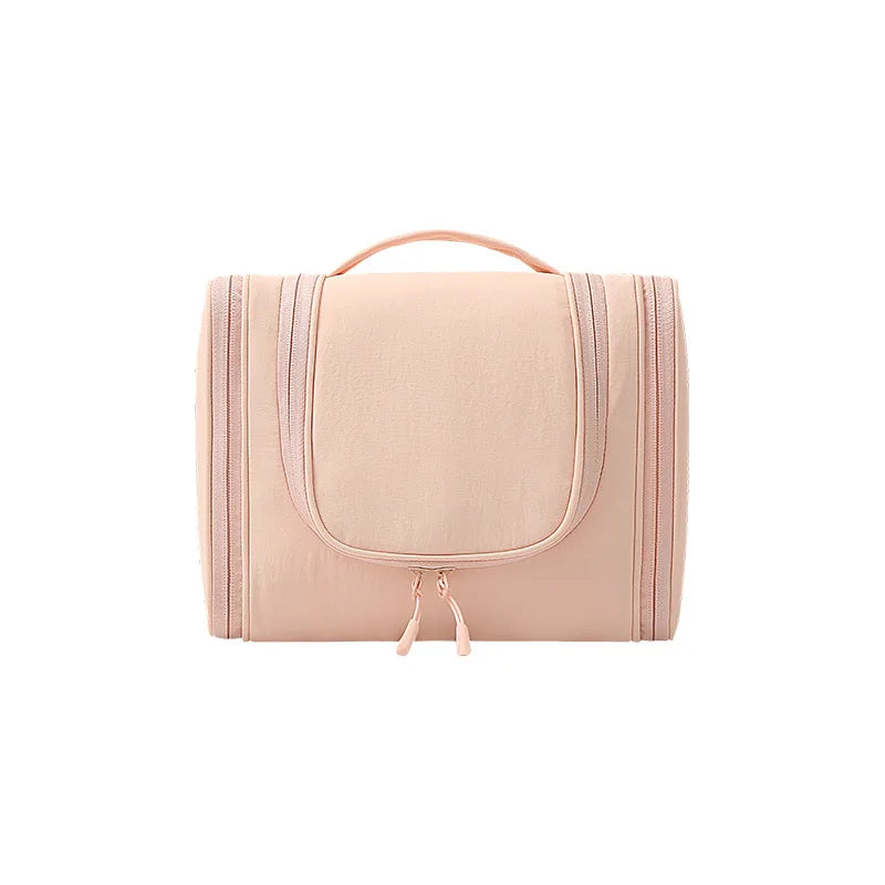 A light pink waterproof hanging toiletry bag with a handle and zipper.
