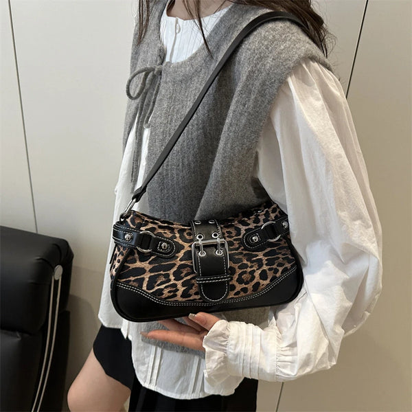 A woman wearing a white blouse and gray vest holds a black leopard print PU shoulder bag.