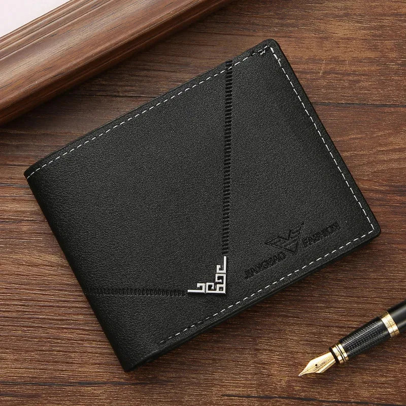 A black slim men's leather RFID blocking bi-fold wallet resting on a wooden surface next to a pen.