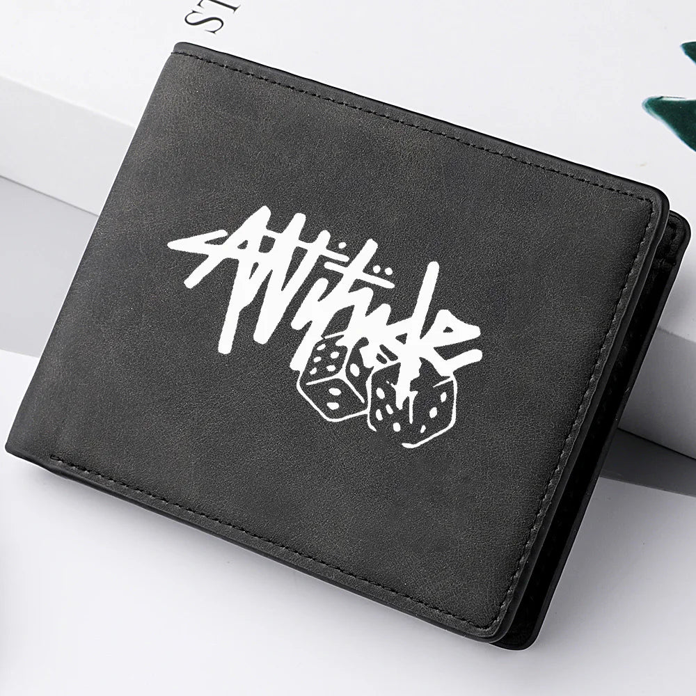 A black PU leather wallet featuring a white cartoon print of the word Attitude and dice.