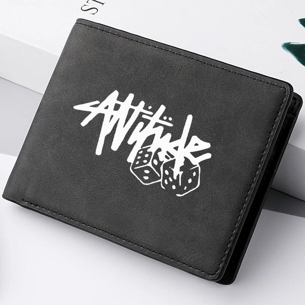 A black PU leather wallet featuring a white cartoon print of the word Attitude and dice.