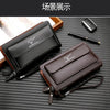 Portefeuille à double zip marron pour homme, ouvert sur une surface sombre.