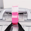 A pink and white adjustable luggage strap with a buckle is shown attached to a silver suitcase handle.