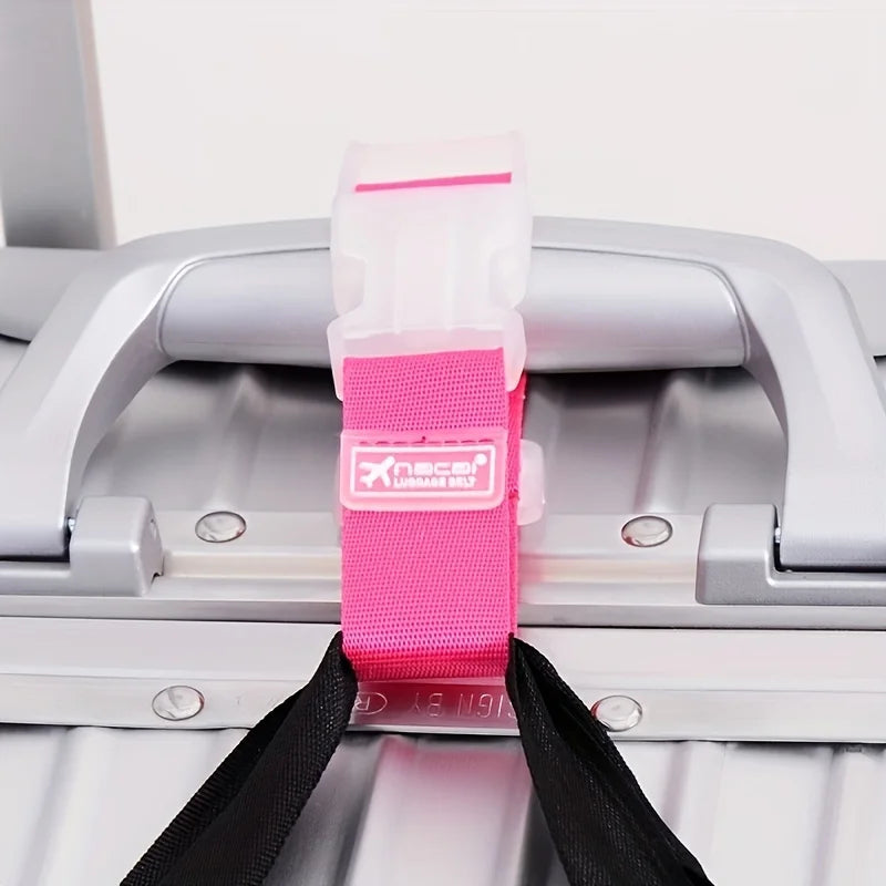A pink and white adjustable luggage strap with a buckle is shown attached to a silver suitcase handle.